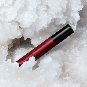 Applying AHAVA Dead Sea mineral serum to reduce facial wrinkles